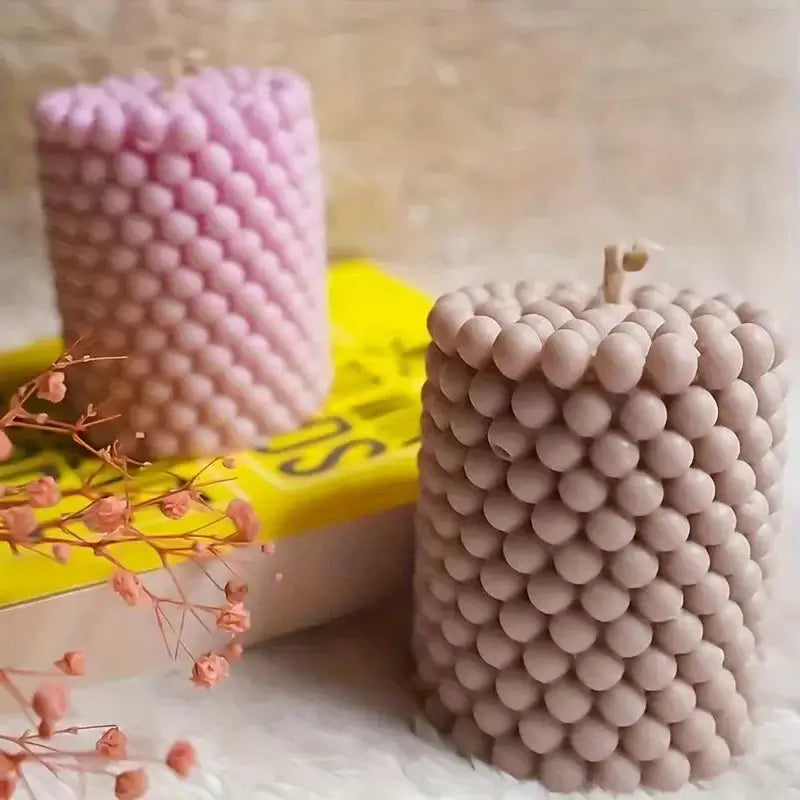 Two unique bubble candles created using a bubble candle mold, showcasing different colors and bubble designs.