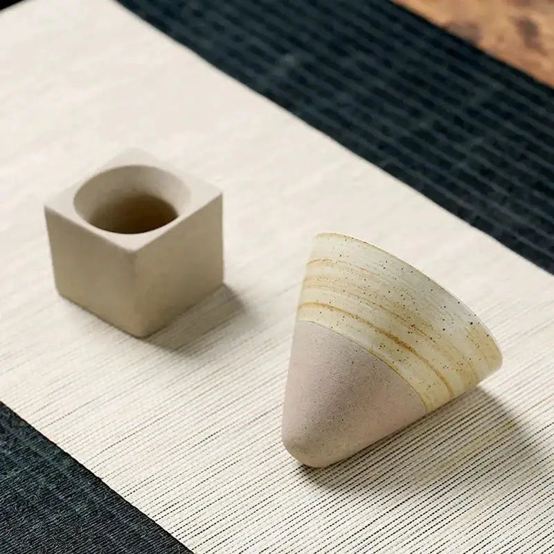 Japanese Retro Ceramic Coffee Cup displayed on a textured fabric surface with a square and cone-shaped design.