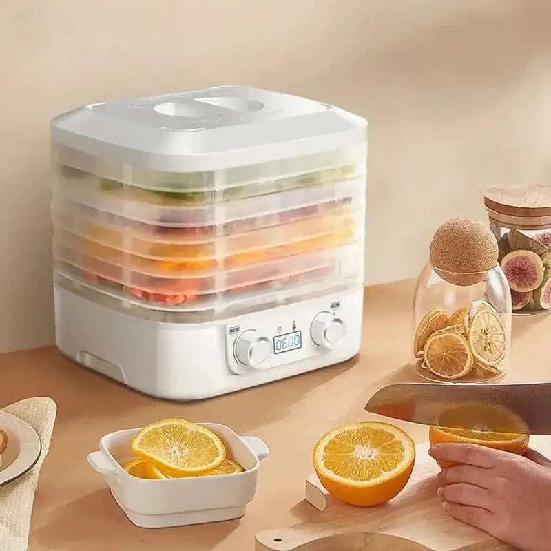 ThermoSafe Food Dehydrator - NestNexus with stacked trays of fruit and a cutting board with fresh oranges.