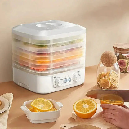 ThermoSafe Food Dehydrator - NestNexus with stacked trays of fruit and a cutting board with fresh oranges.